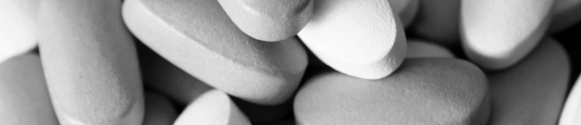 colored oblong pills on the isolated background – grey scale